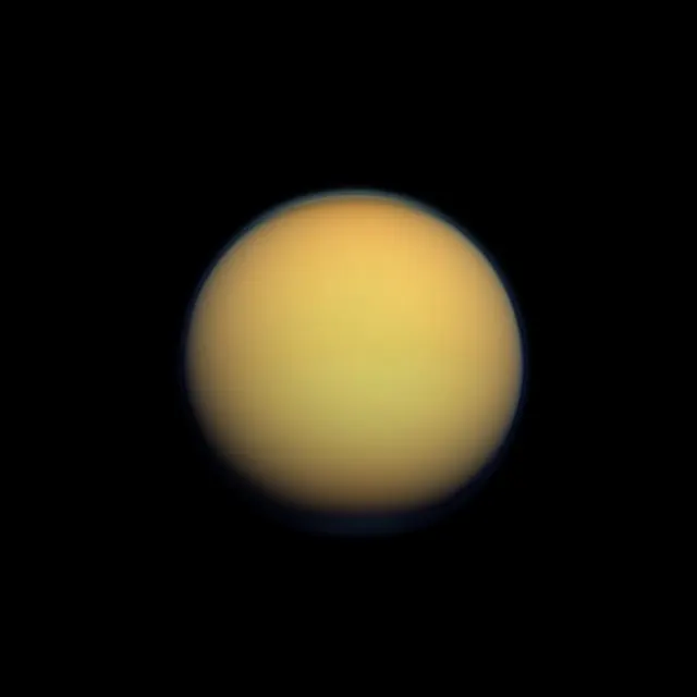 Titán, una esfera anaranjada y difuminada por su atmósfera espesa, en color natural, fotografiada por Cassini
