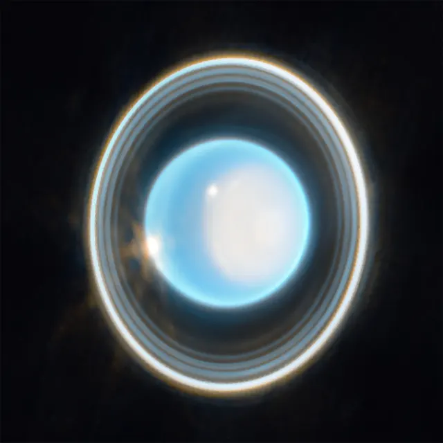 Urano, azul claro, con sus anillos finos alrededor, fotografiado por el telescopio James Webb